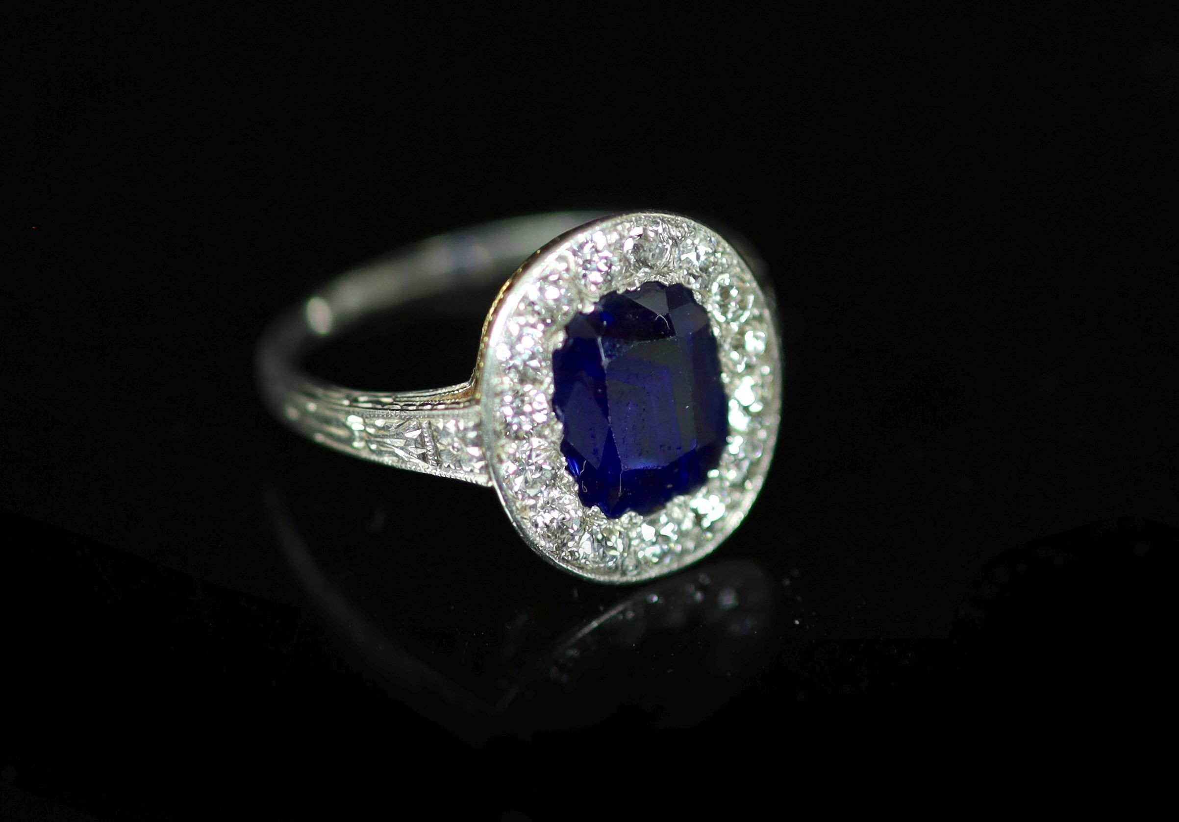 A 1930's platinum and gold, sapphire and diamond set oval cluster ring